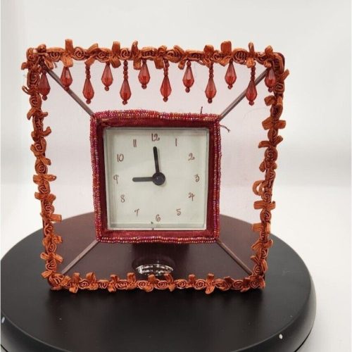 Orange decorative clock with beaded accent for stylish home decor.