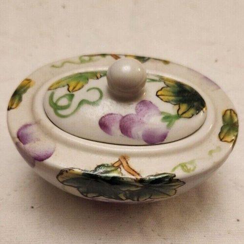 Hand-painted vintage porcelain oval trinket box with grape pattern and lid.