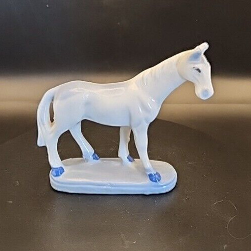 Vintage white horse sculpture with blue accent shading for home decor.