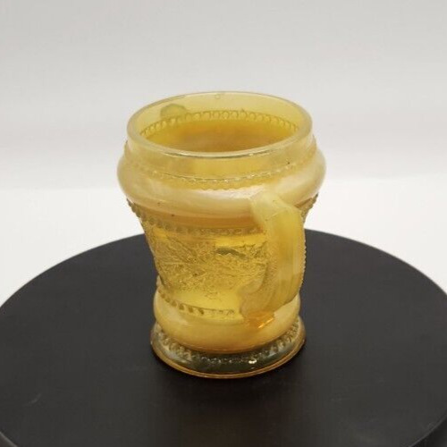 Amber Holly hand-blown art glass spooner with two handles and vibrant amber coloration.