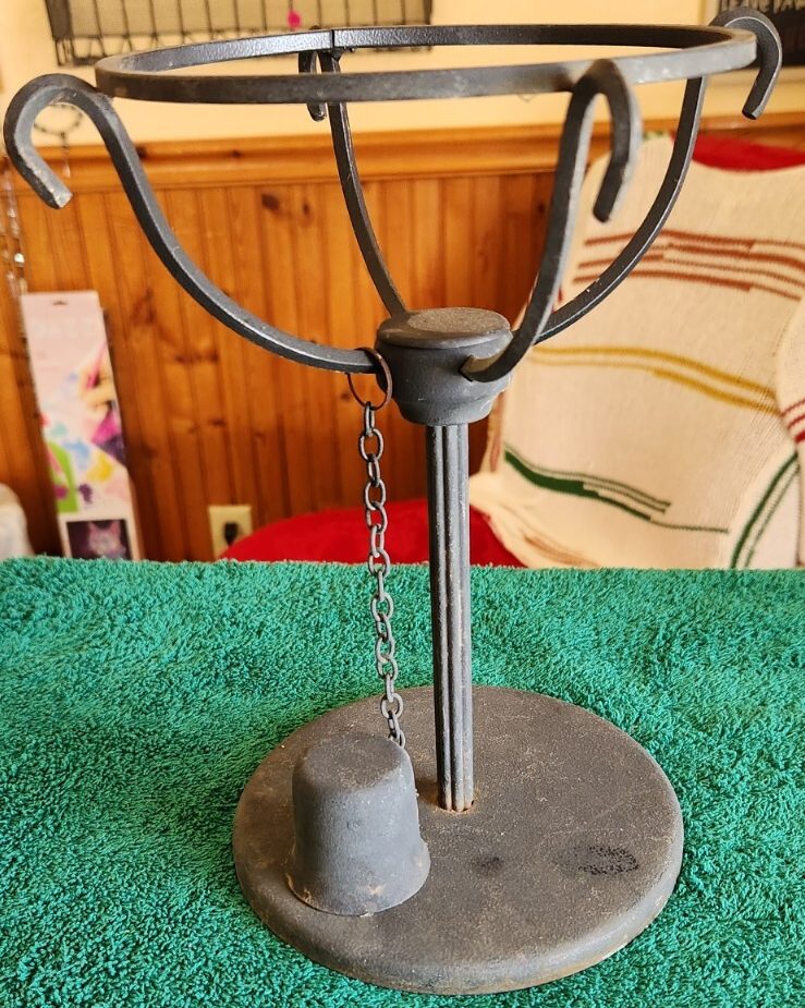 Vintage black metal candle holder with attached snuffer for classic home decor.