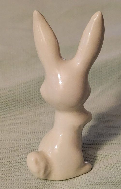 Small ceramic bunny figurine with blue eyes and detailed craftsmanship.