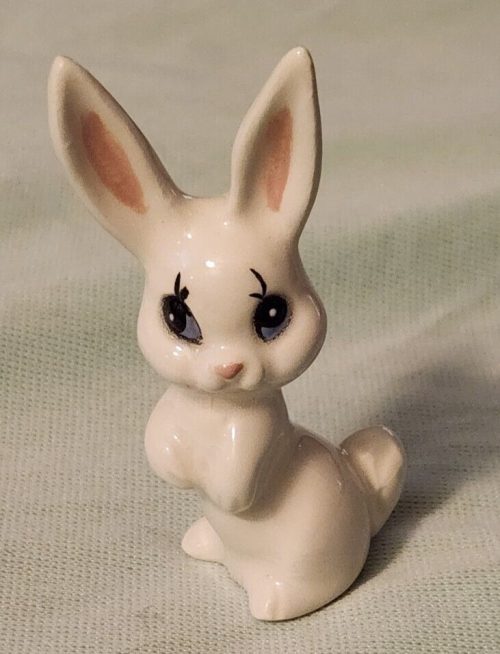Miniature ceramic bunny figurine with blue eyes for decorative collectibles and Easter decorations.