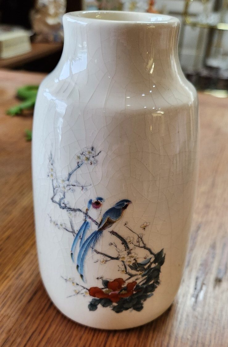 Colorful bird of paradise floral arrangement in a decorative vase.