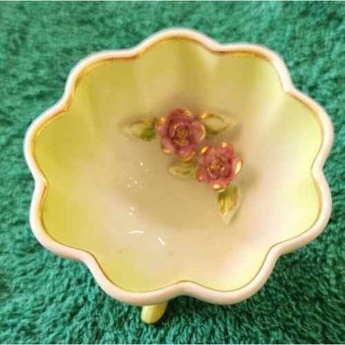Decorative porcelain footed trinket bowl with gold trim and delicate floral design.