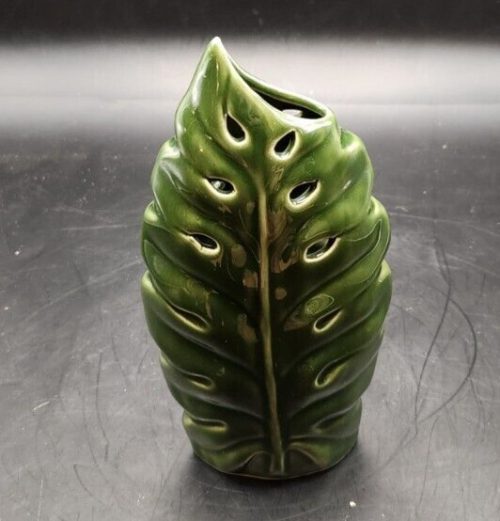 Green ceramic vase with leaf glaze design for floral or decorative displays.