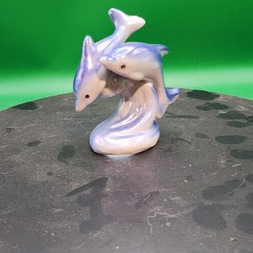 Iridescent dolphin lusterware figurine with shimmering finish, decorative ceramic ocean animal sculpture.