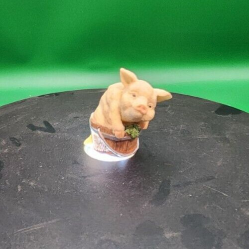 Pink resin pig figurine in a pale pink setting, perfect for decorative or collectible purposes.