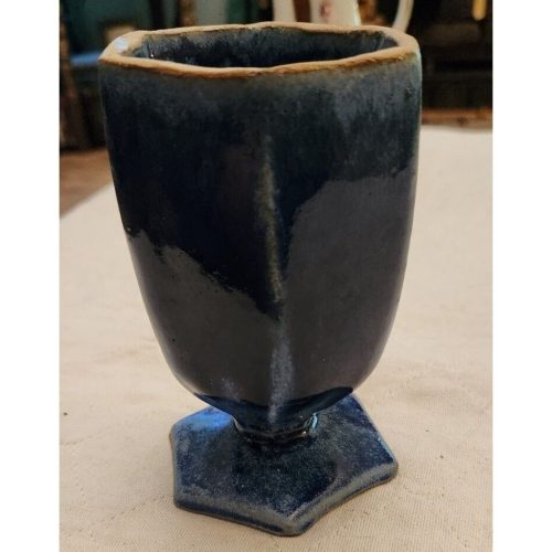 Signed hexagonal stoneware drinking vessel with unique craftsmanship and durable ceramic design.