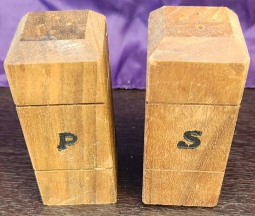 Salt and pepper shakers on a square wooden block, kitchen spice set.