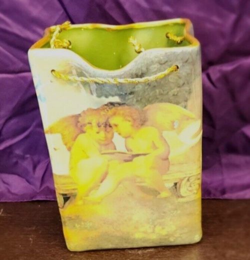 Handcrafted ceramic cherub bag-shaped décor ornament.