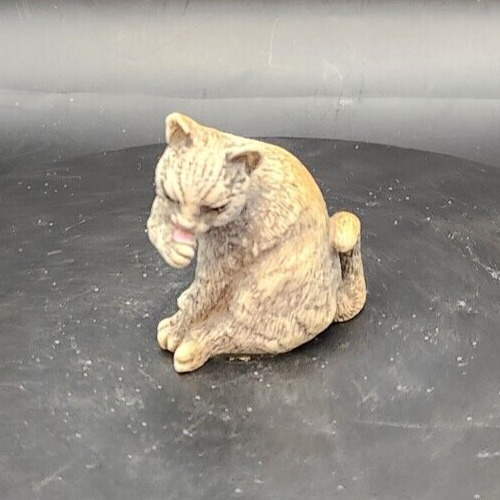 Artis Onia Rinke Nada cat figurine licking paw, decorative feline sculpture.