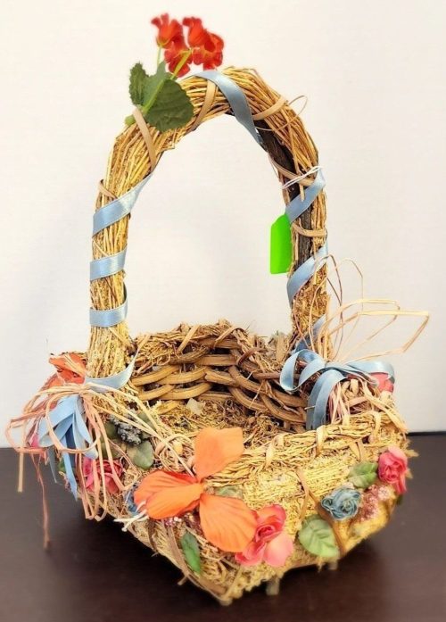 Decorative straw basket with colorful embellishments for home decor and craft projects.