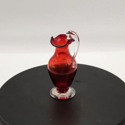 Hand-blown red glass mini pitcher with clear spun handle, 4.75 inches tall.
