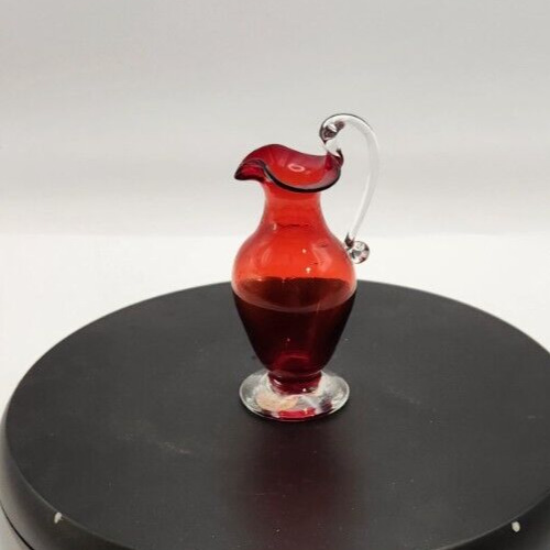 Hand-blown red glass mini pitcher with clear spun handle, 4.75 inches tall.