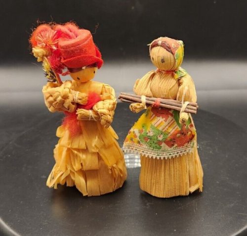Handmade corn husk dolls with fabric accents, measuring 5 inches by 2 inches.