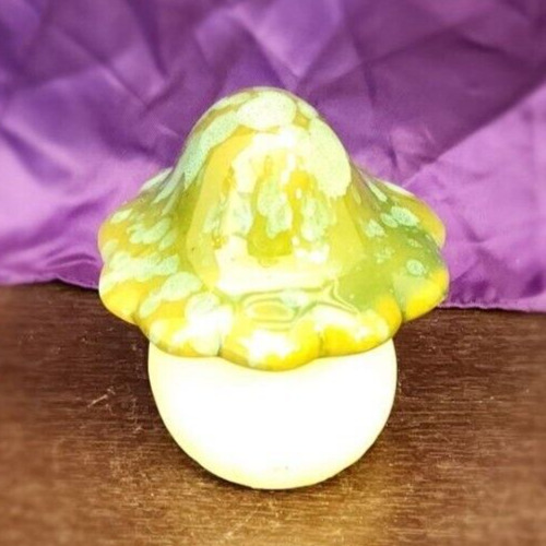 Handmade ceramic mushroom sculpture with green glaze and drip paint decoration.