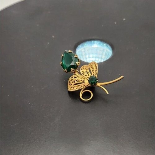 Vintage gold-tone flower brooch with emerald green rhinestones and prong setting.