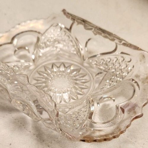 Vintage scalloped glass candy dish with decorative rolled edges.